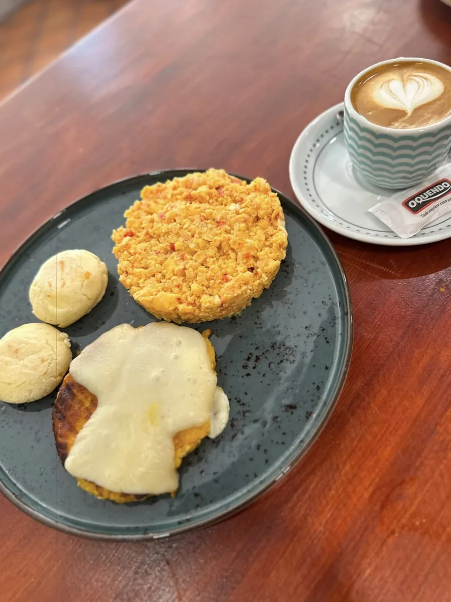 Desayuno con arepas, huevos revueltos y café con arte latte